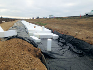 Prior to placing the geofoam blocks, the trench was lined with a gas-resistant membrane that protects the geofoam from oil and gas contaminants in roadway runoff.